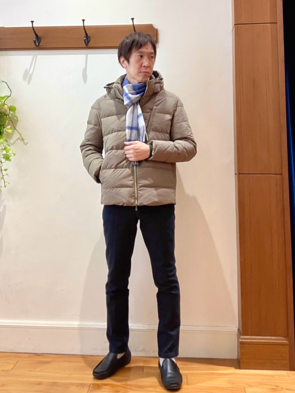 グリーン系のダウンジャケット/コート、ブルー系のニット/セーター、ブルー系のデニムパンツを着用したメンズの冬コーディネートの2枚目の写真