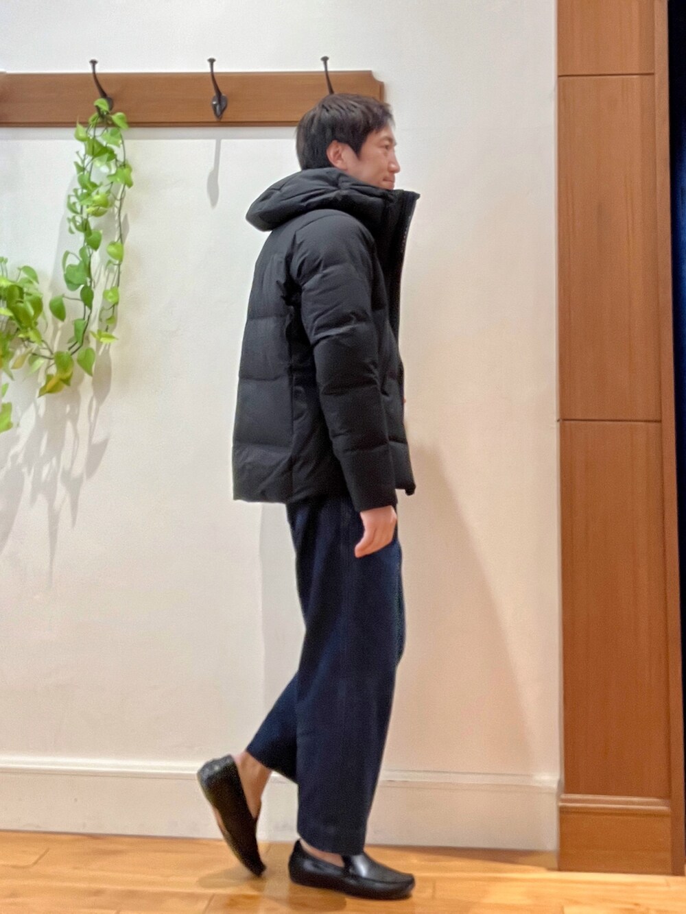 ブラック系のダウンジャケット/コート、オレンジ系のニット/セーターを着用したメンズの秋コーディネートの6枚目の写真