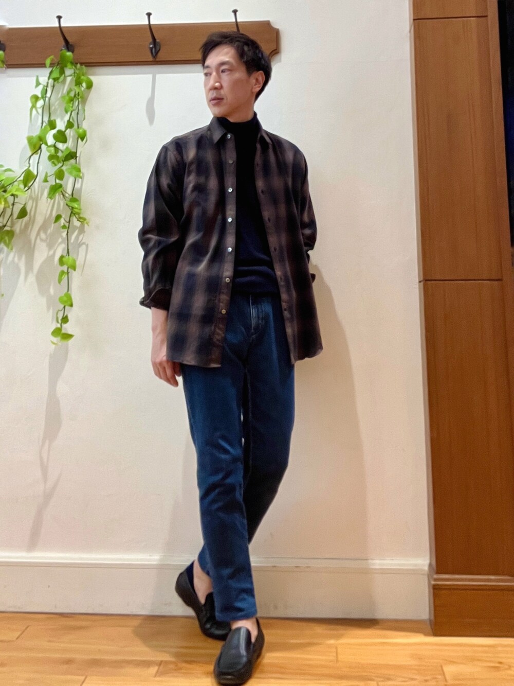 グリーン系のシャツ/ブラウス、ブルー系のニット/セーター、ブルー系のデニムパンツを着用したメンズの冬コーディネートの8枚目の写真