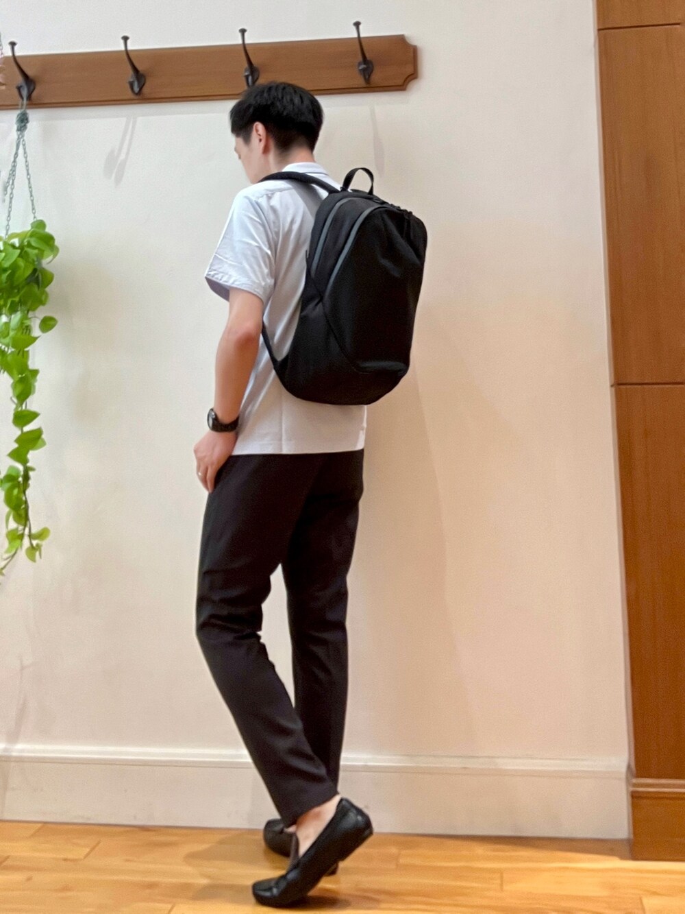 ブルー系のポロシャツ、ブラウン系のその他パンツ、ブラック系のバックパック/リュックを着用したメンズの夏コーディネートの4枚目の写真