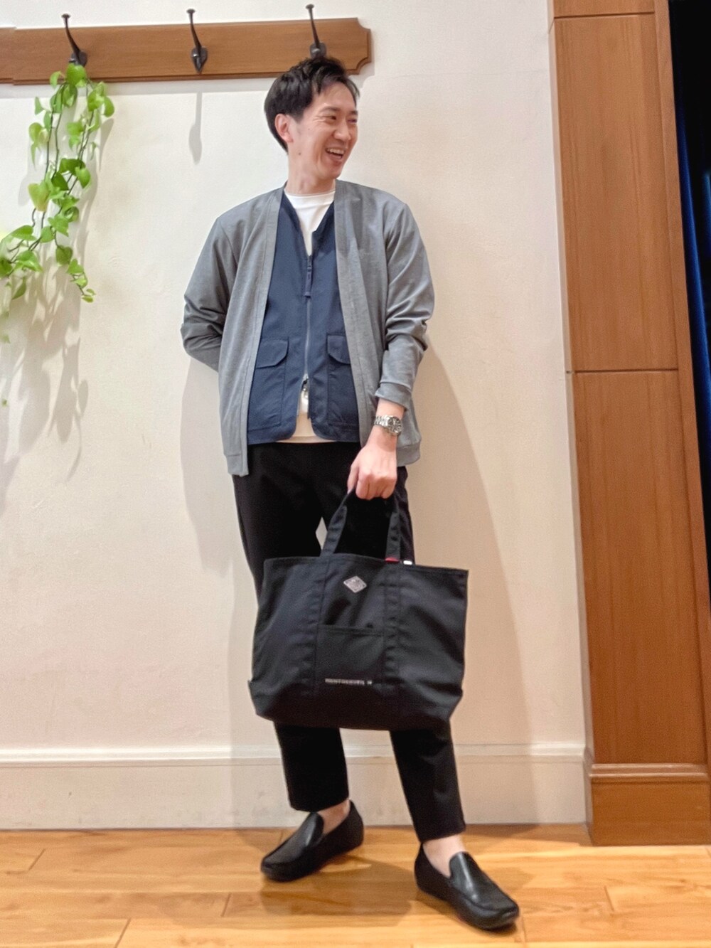 ブラック系のトートバッグ、ブラック系のその他パンツ、ホワイト系のTシャツ/カットソーを着用したメンズの春コーディネートの2枚目の写真