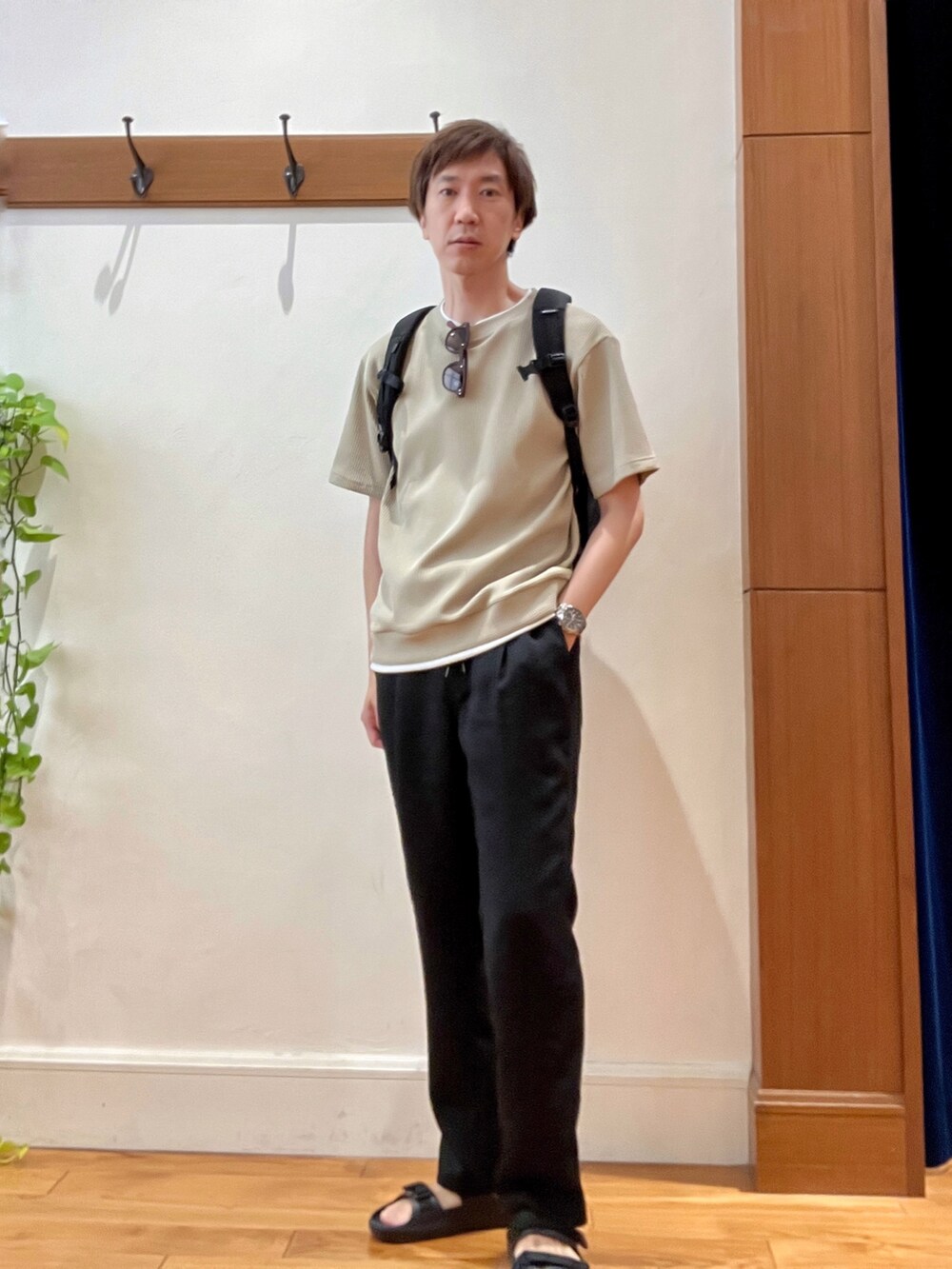 ブラック系のバックパック/リュック、ベージュ系のTシャツ/カットソー、ブラック系のサンダルを着用したメンズの夏コーディネートの7枚目の写真