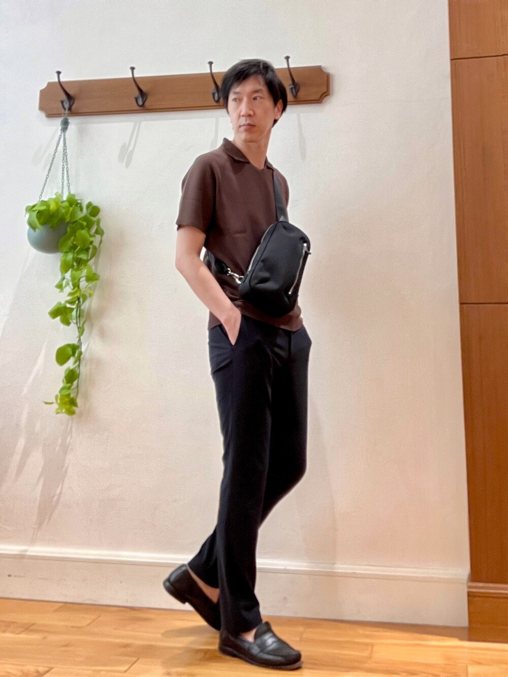 ブラウン系のポロシャツ、ブルー系のその他パンツ、ブラック系のボディバッグ/ウエストポーチを着用したメンズの春コーディネートの4枚目の写真