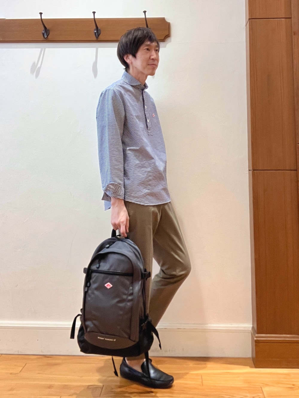 ブルー系のシャツ/ブラウス、グレー系のバックパック/リュック、グリーン系のチノパンツを着用したメンズの春コーディネートの6枚目の写真