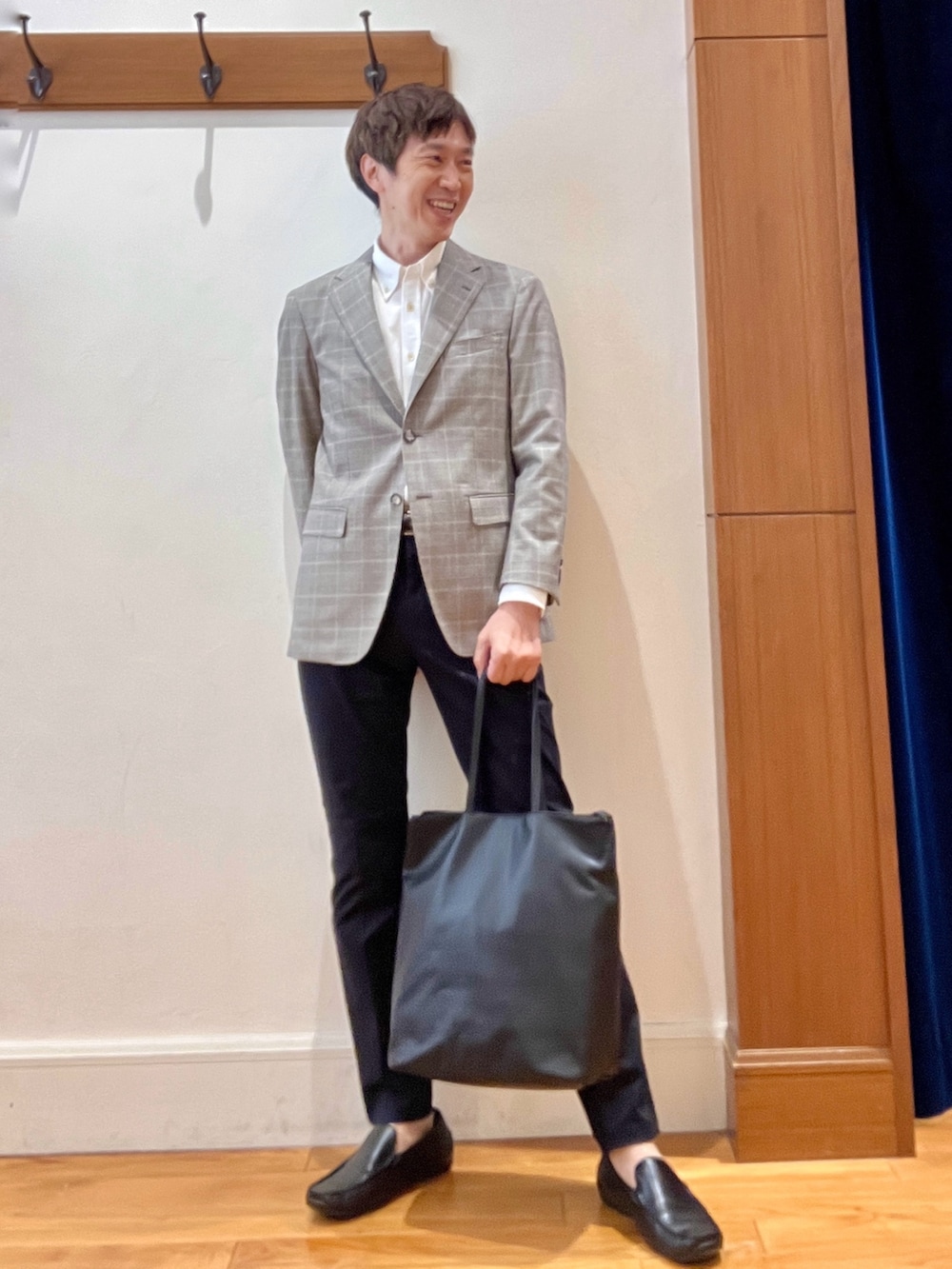 ブラック系のトートバッグ、ブルー系のチノパンツ、ブラウン系のテーラードジャケットを着用したメンズの夏コーディネートの8枚目の写真