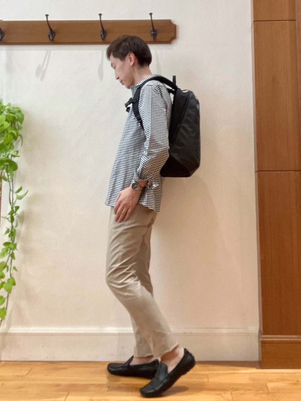 ブラック系のシャツ/ブラウス、グレー系のバックパック/リュック、ベージュ系のチノパンツを着用したメンズの春コーディネートの3枚目の写真