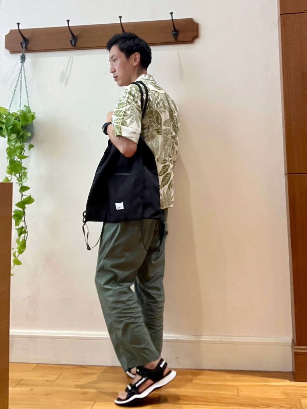 ブラック系のトートバッグ、ホワイト系のTシャツ/カットソー、グリーン系のシャツ/ブラウスを着用したメンズの夏コーディネートの3枚目の写真