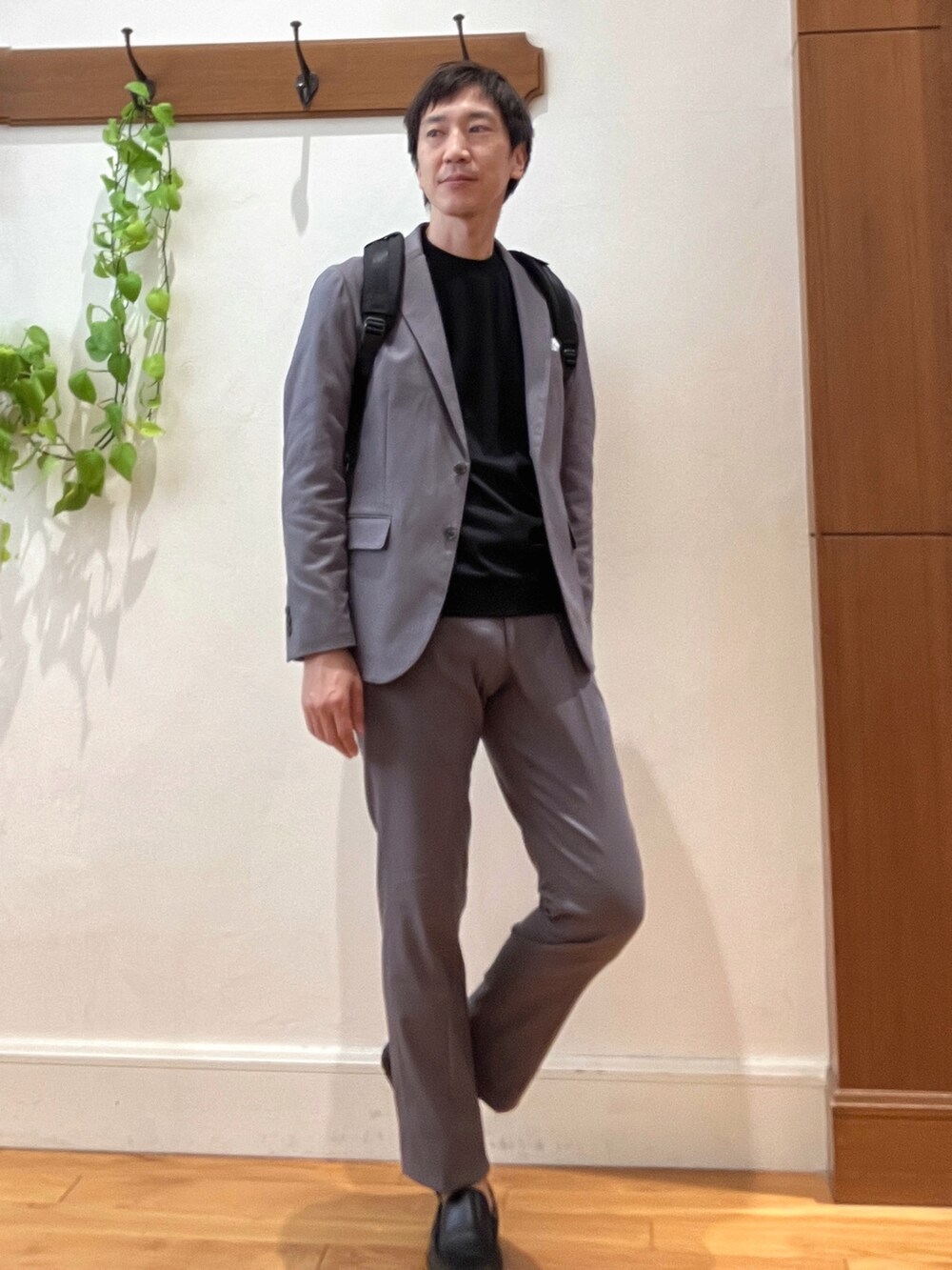 ブラック系のバックパック/リュック、ブラック系のTシャツ/カットソー、グレー系のテーラードジャケットを着用したメンズの秋コーディネートの7枚目の写真