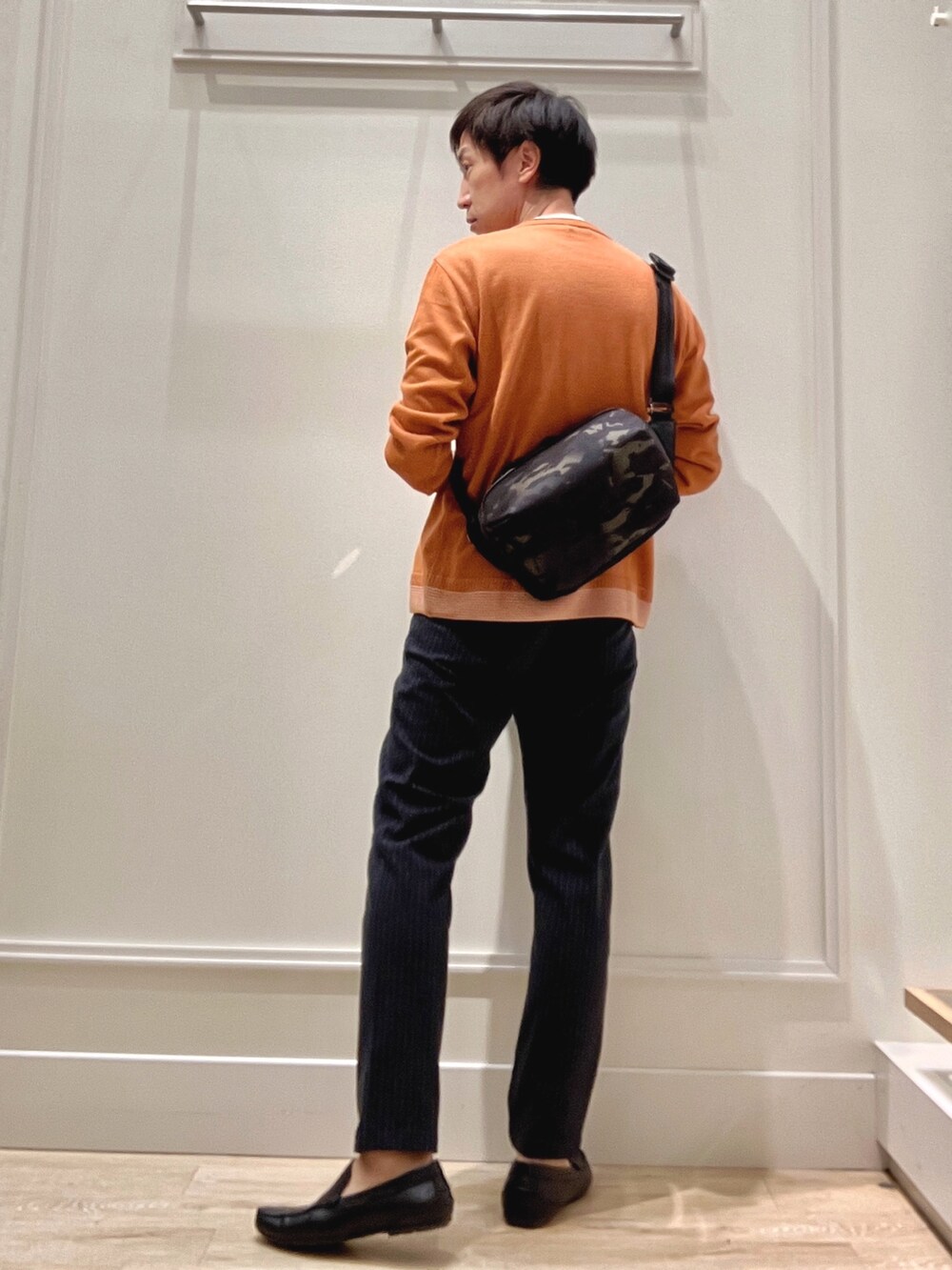 イエロー系のニット/セーター、ブラック系のショルダーバッグ、ブルー系のその他パンツを着用したメンズの秋コーディネートの5枚目の写真
