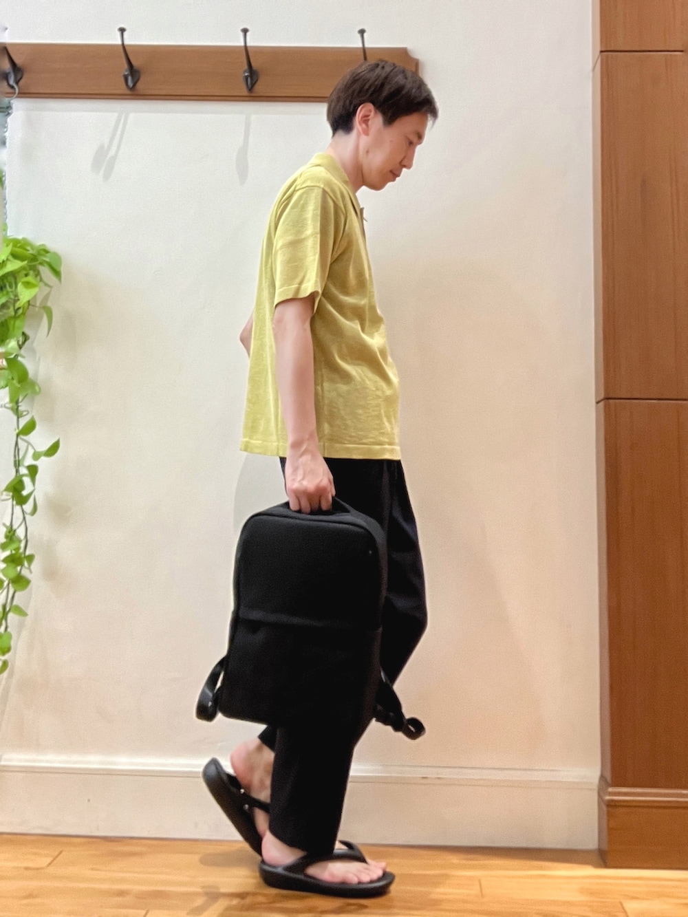イエロー系のニット/セーター、ブルー系のその他パンツ、ブラック系のバックパック/リュックを着用したメンズの春コーディネートの5枚目の写真