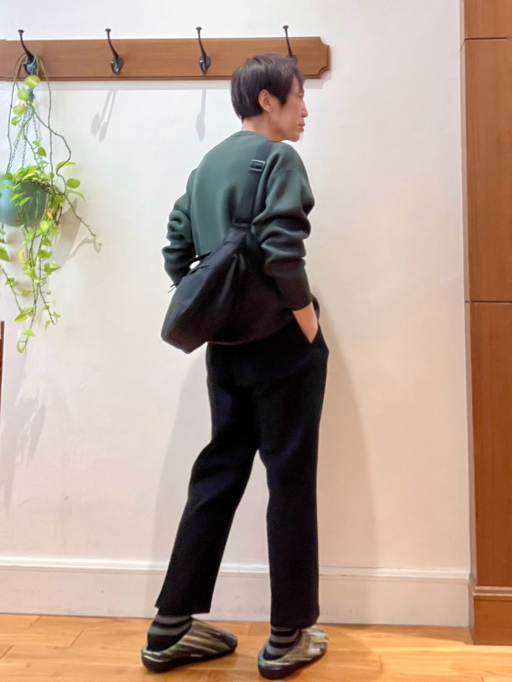 グリーン系のニット/セーター、ブラック系のショルダーバッグ、グリーン系のサンダルを着用したメンズの冬コーディネートの6枚目の写真