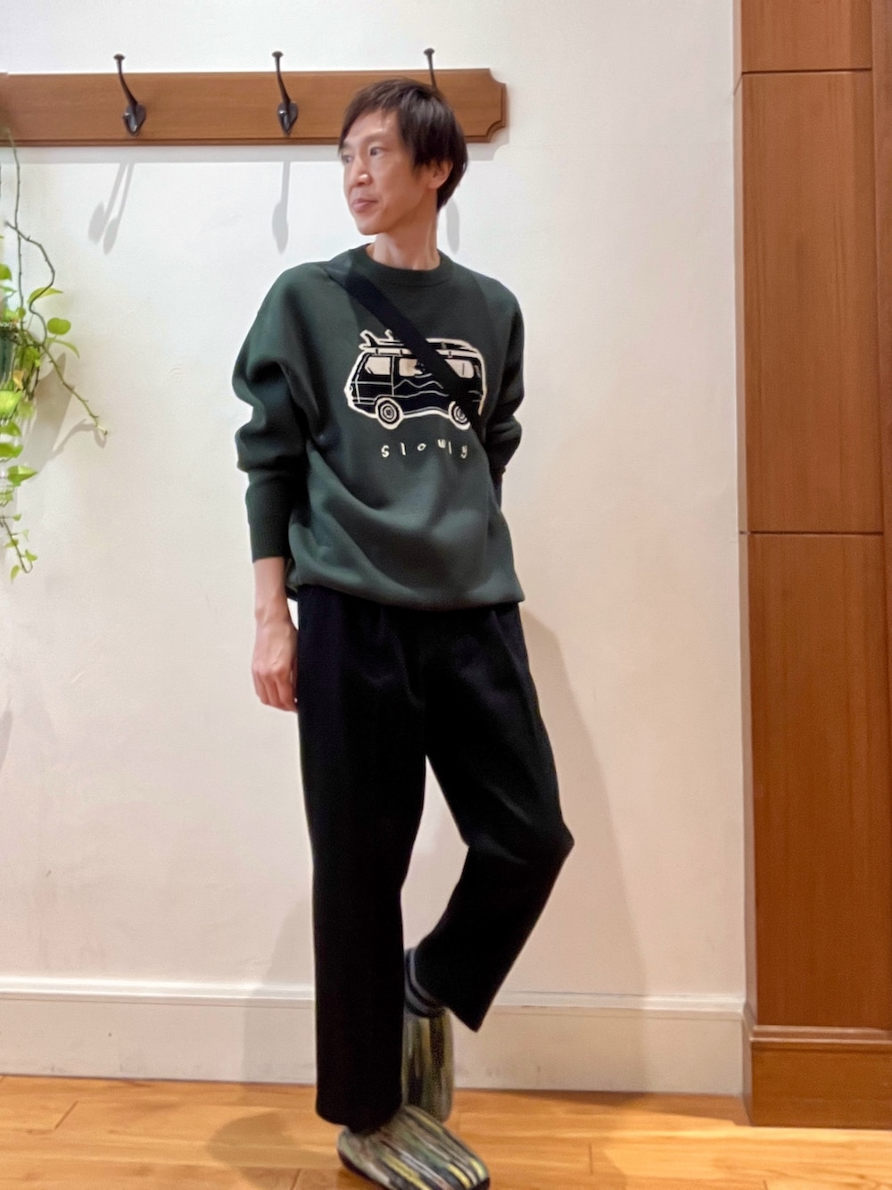 グリーン系のニット/セーター、ブラック系のショルダーバッグ、グリーン系のサンダルを着用したメンズの冬コーディネートの7枚目の写真