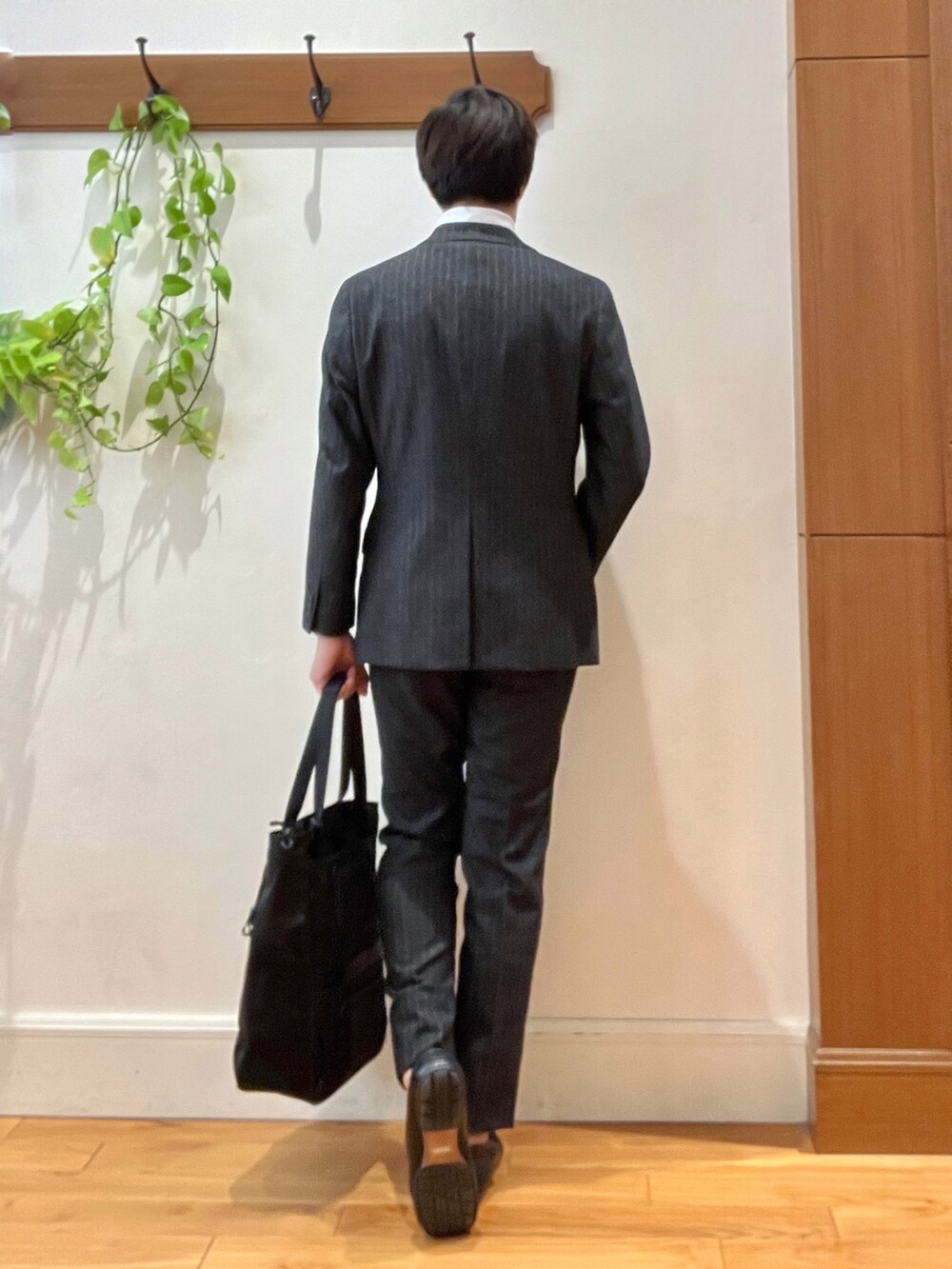 グレー系のテーラードジャケット、ホワイト系のTシャツ/カットソー、グレー系のスラックスを着用したメンズの秋コーディネートの5枚目の写真