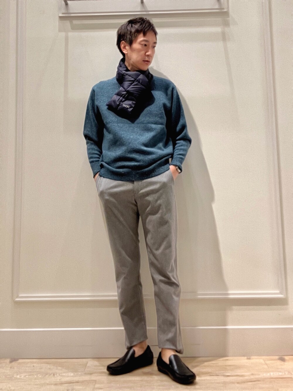 グリーン系のニット/セーター、グレー系のその他パンツ、ブルー系のマフラーを着用したメンズの冬コーディネートの2枚目の写真