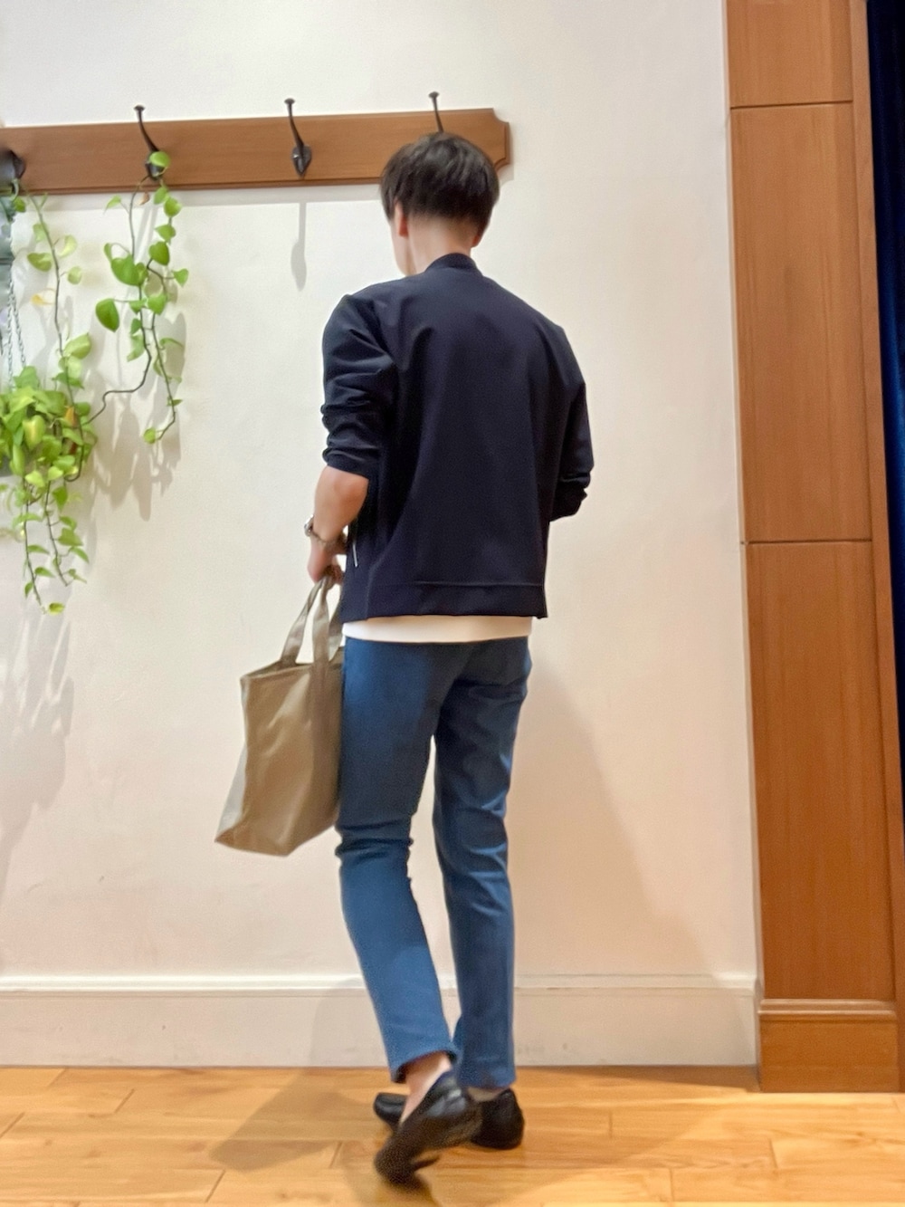 ブルー系のデニムパンツ、ベージュ系のトートバッグ、ホワイト系のTシャツ/カットソーを着用したメンズの秋コーディネートの6枚目の写真
