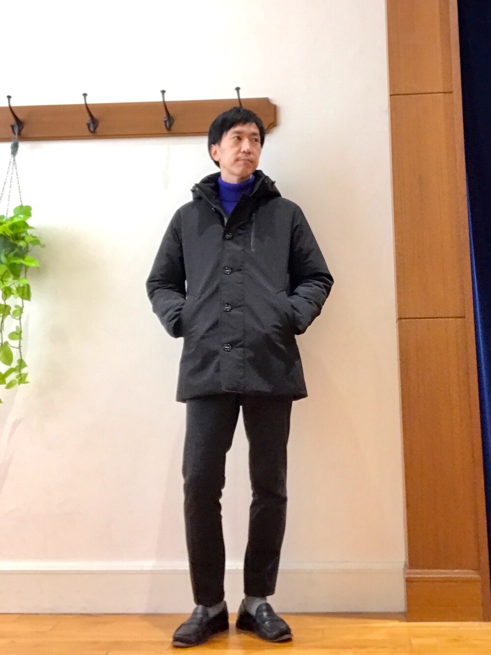 ブラック系のダウンジャケット/コート、ブルー系のニット/セーター、グレー系のその他パンツを着用したメンズの冬コーディネートの3枚目の写真