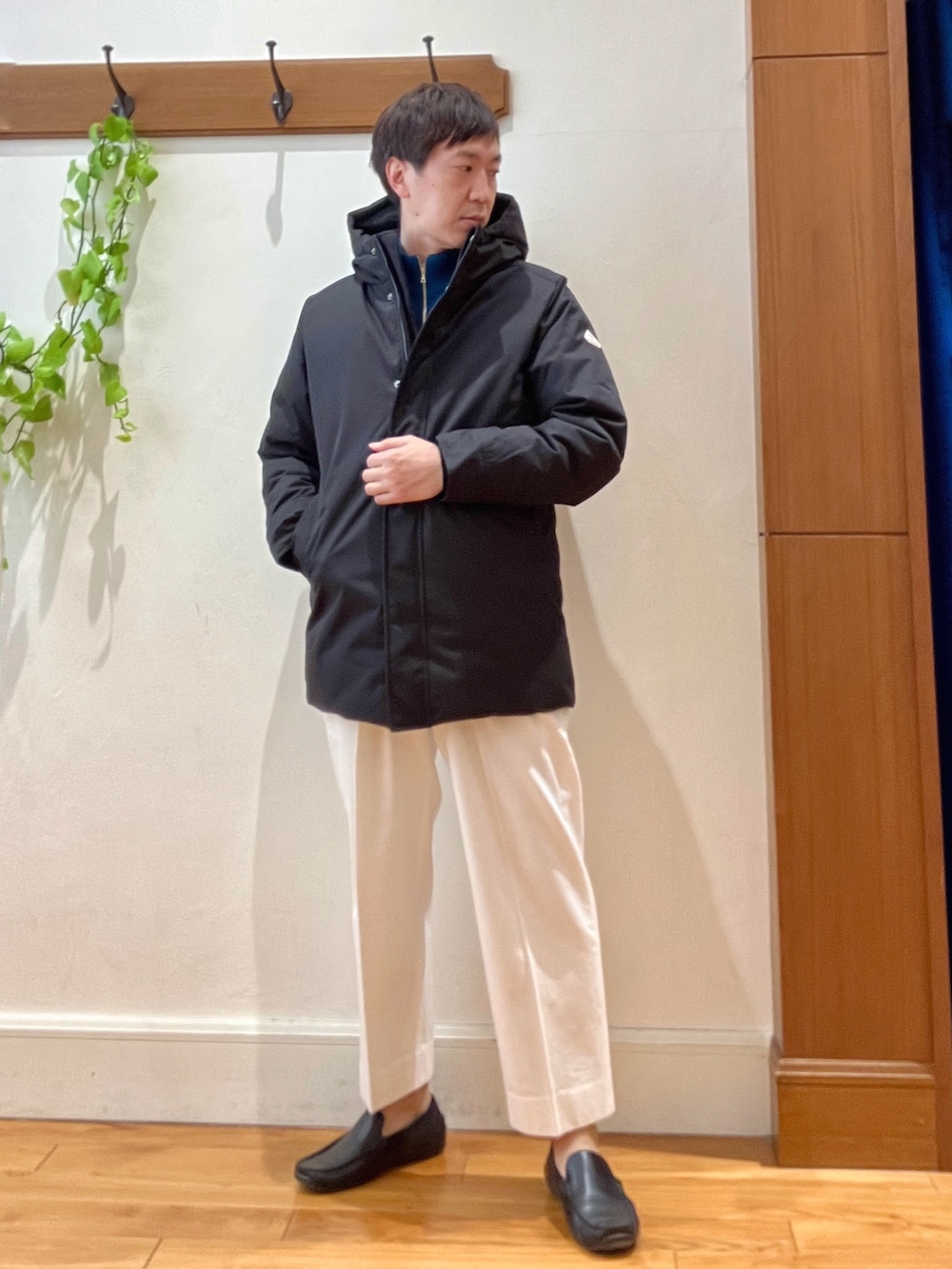 ホワイト系のTシャツ/カットソー、ブラック系のダウンジャケット/コート、ブルー系のカーディガン/ボレロを着用したメンズの冬コーディネートの7枚目の写真