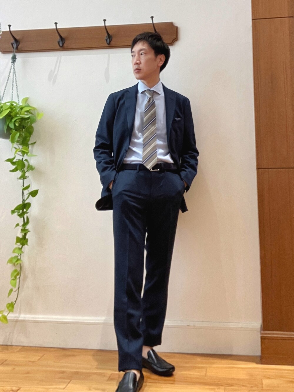 ブラック系のトートバッグ、ブルー系のスラックス、ベージュ系のネクタイを着用したメンズの秋コーディネートの7枚目の写真