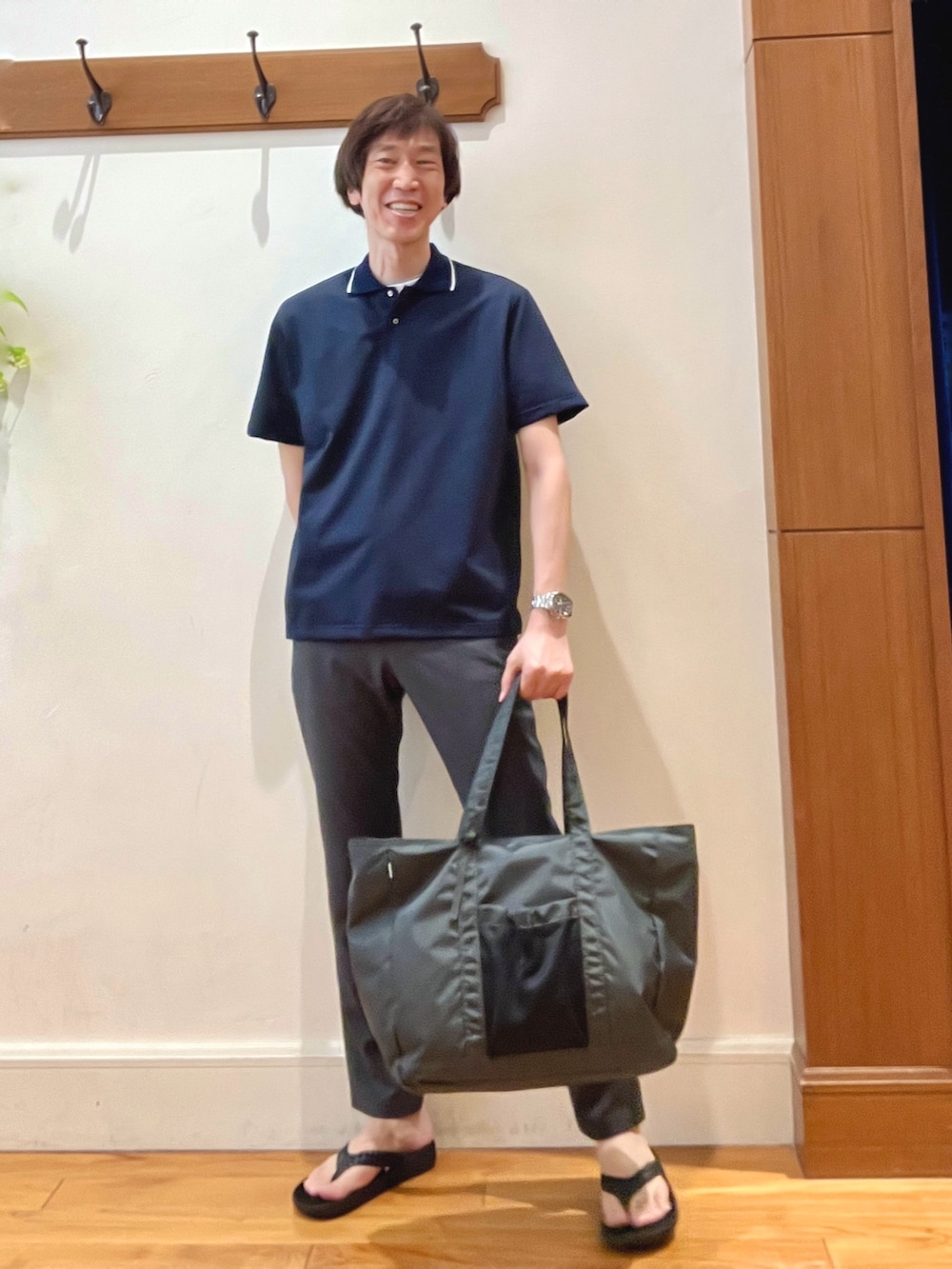 グレー系のトートバッグ、グレー系のその他パンツ、ブラック系のサンダルを着用したメンズの夏コーディネートの2枚目の写真