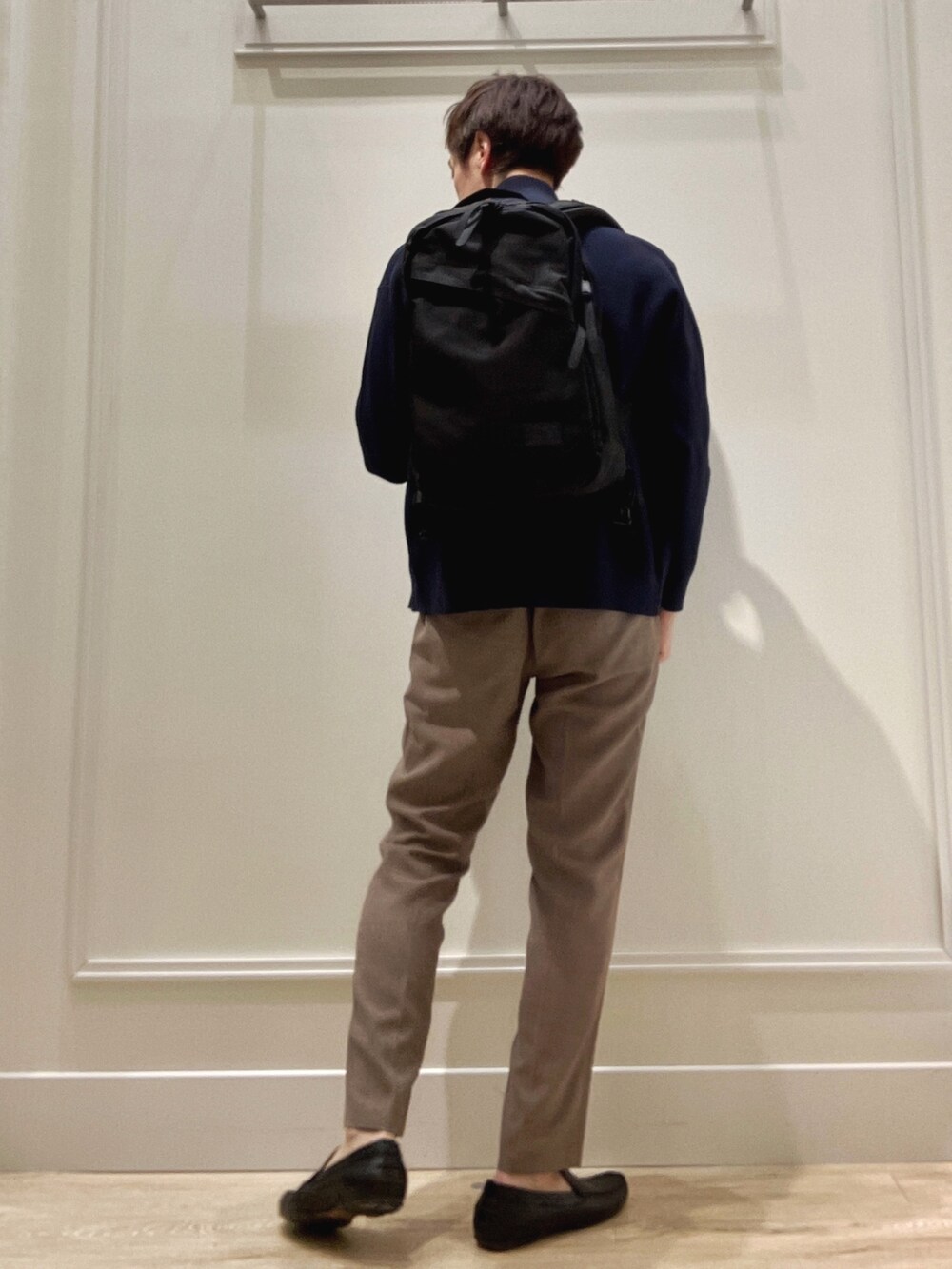 ブルー系のニット/セーター、ホワイト系のTシャツ/カットソー、ベージュ系のその他パンツを着用したメンズの冬コーディネートの4枚目の写真