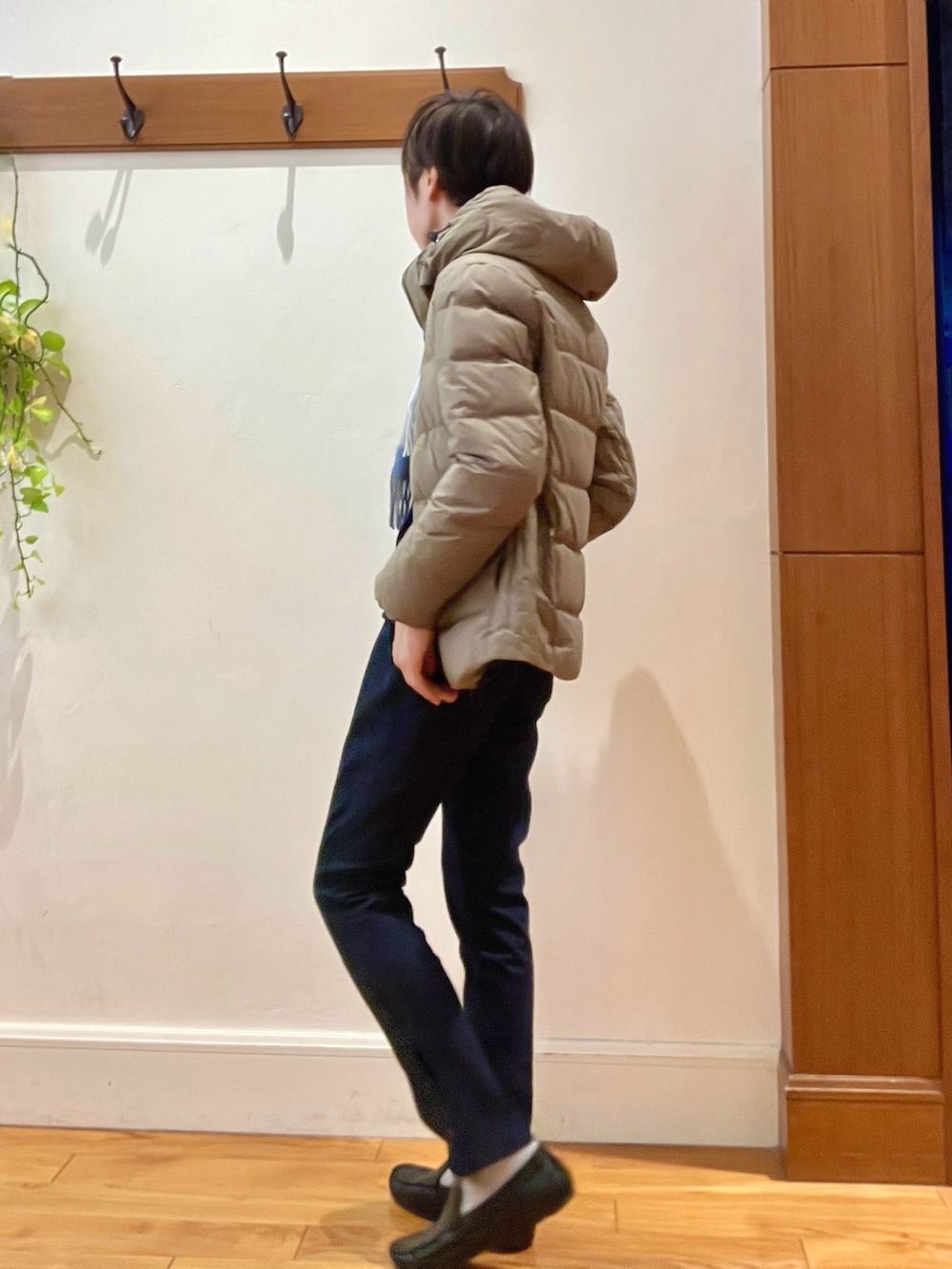 グリーン系のダウンジャケット/コート、ブルー系のニット/セーター、ブルー系のデニムパンツを着用したメンズの冬コーディネートの4枚目の写真