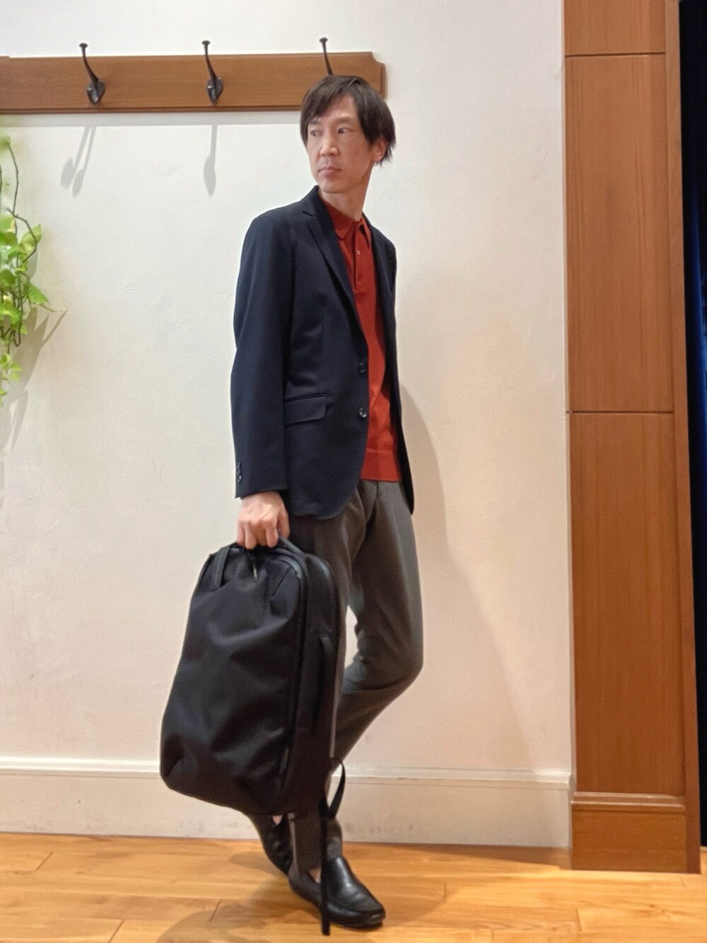 ブルー系のテーラードジャケット、レッド系のニット/セーター、グレー系のその他パンツを着用したメンズの秋コーディネートの7枚目の写真