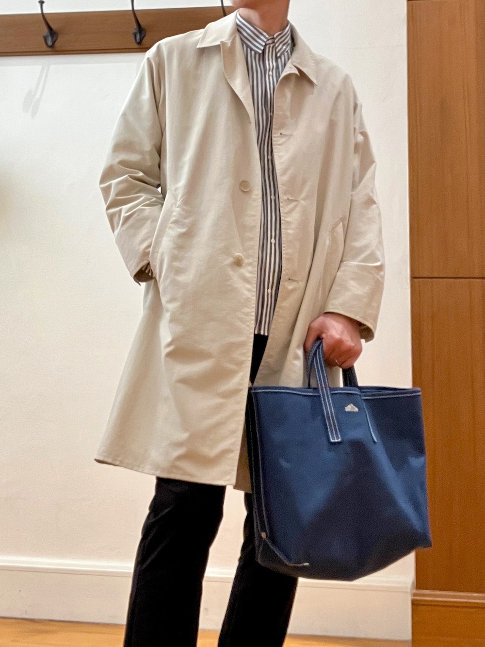 ホワイト系のステンカラーコート、グレー系のシャツ/ブラウス、レッド系のトートバッグを着用したメンズの春コーディネートの8枚目の写真