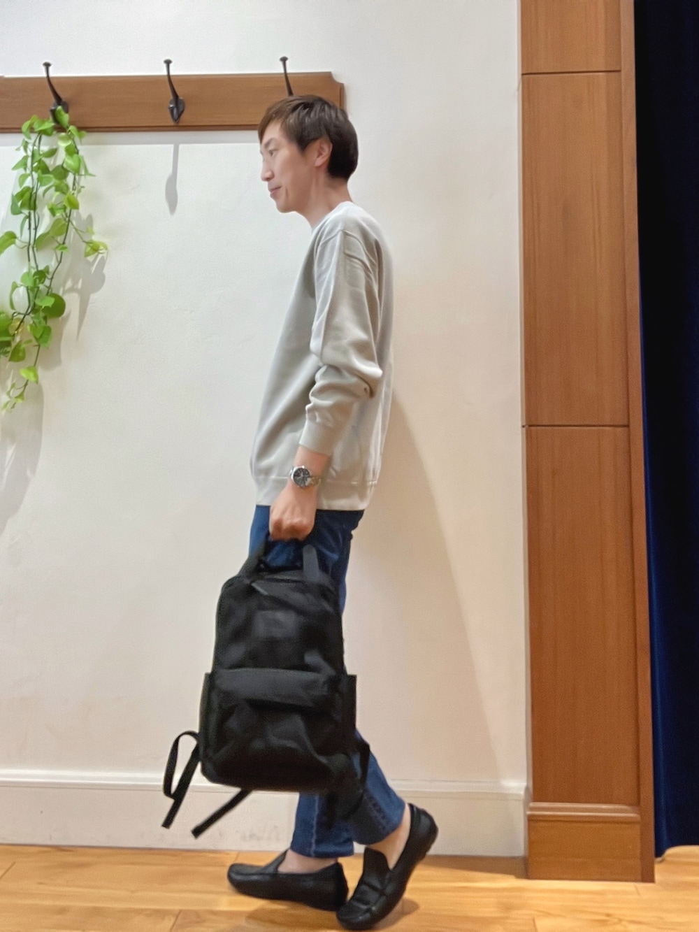 ベージュ系のスウェット、ブルー系のデニムパンツ、ブラック系のバックパック/リュックを着用したメンズの秋コーディネートの3枚目の写真