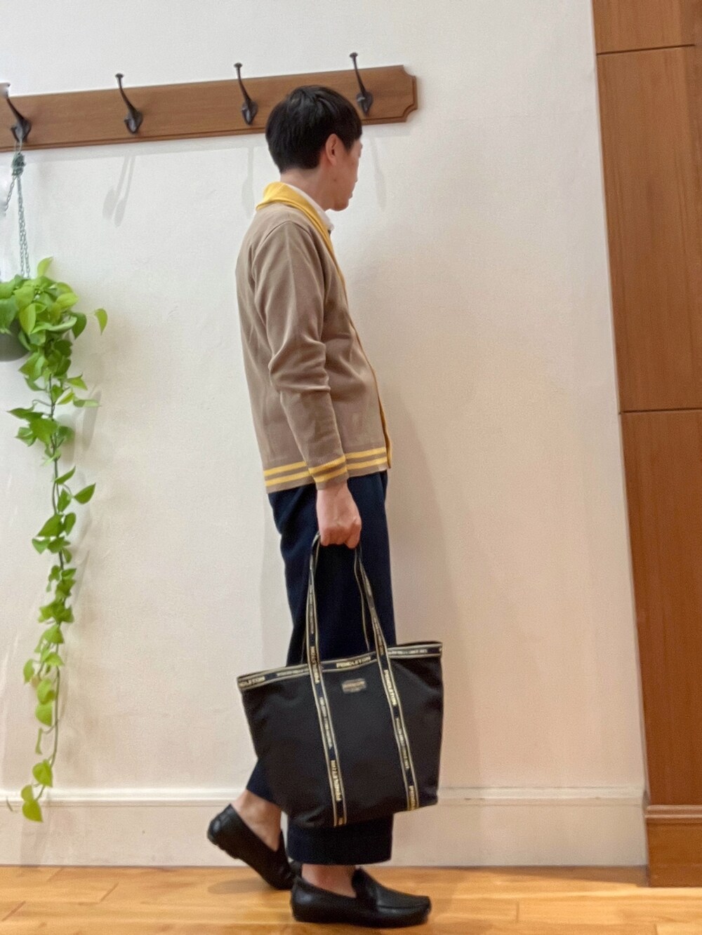 ブルー系のシャツ/ブラウス、ベージュ系のカーディガン/ボレロ、ブラック系のトートバッグを着用したメンズの秋コーディネートの5枚目の写真