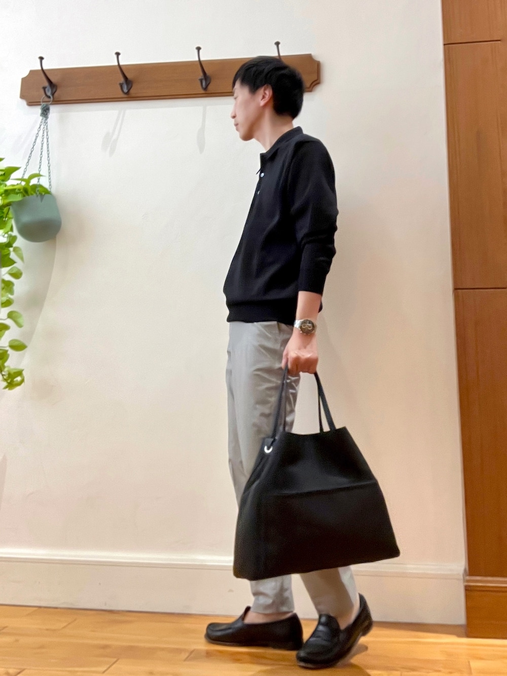 ブラック系のニット/セーター、ベージュ系のその他パンツ、ブラック系のトートバッグを着用したメンズの春コーディネートの4枚目の写真
