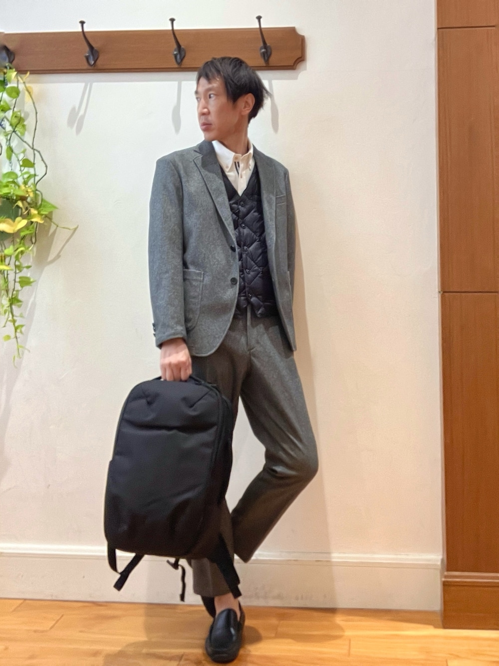 グレー系のテーラードジャケット、ホワイト系のシャツ/ブラウス、ブラック系のダウンベストを着用したメンズの秋コーディネートの7枚目の写真