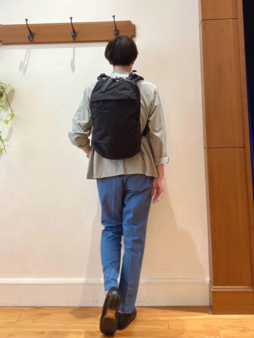 ブラック系のバックパック/リュック、ブルー系のチノパンツ、ブルー系のTシャツ/カットソーを着用したメンズの春コーディネートの4枚目の写真
