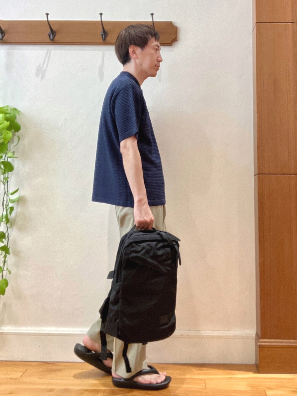 ブルー系のポロシャツ、ベージュ系のその他パンツ、ブラック系のバックパック/リュックを着用したメンズの春コーディネートの7枚目の写真