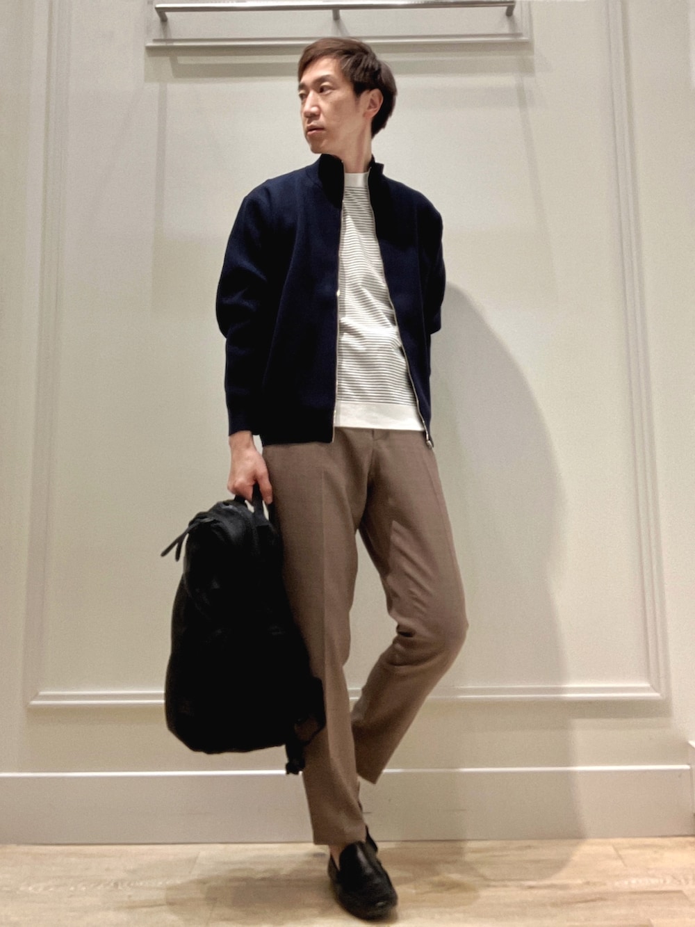 ブルー系のニット/セーター、ホワイト系のTシャツ/カットソー、ベージュ系のその他パンツを着用したメンズの冬コーディネートの6枚目の写真