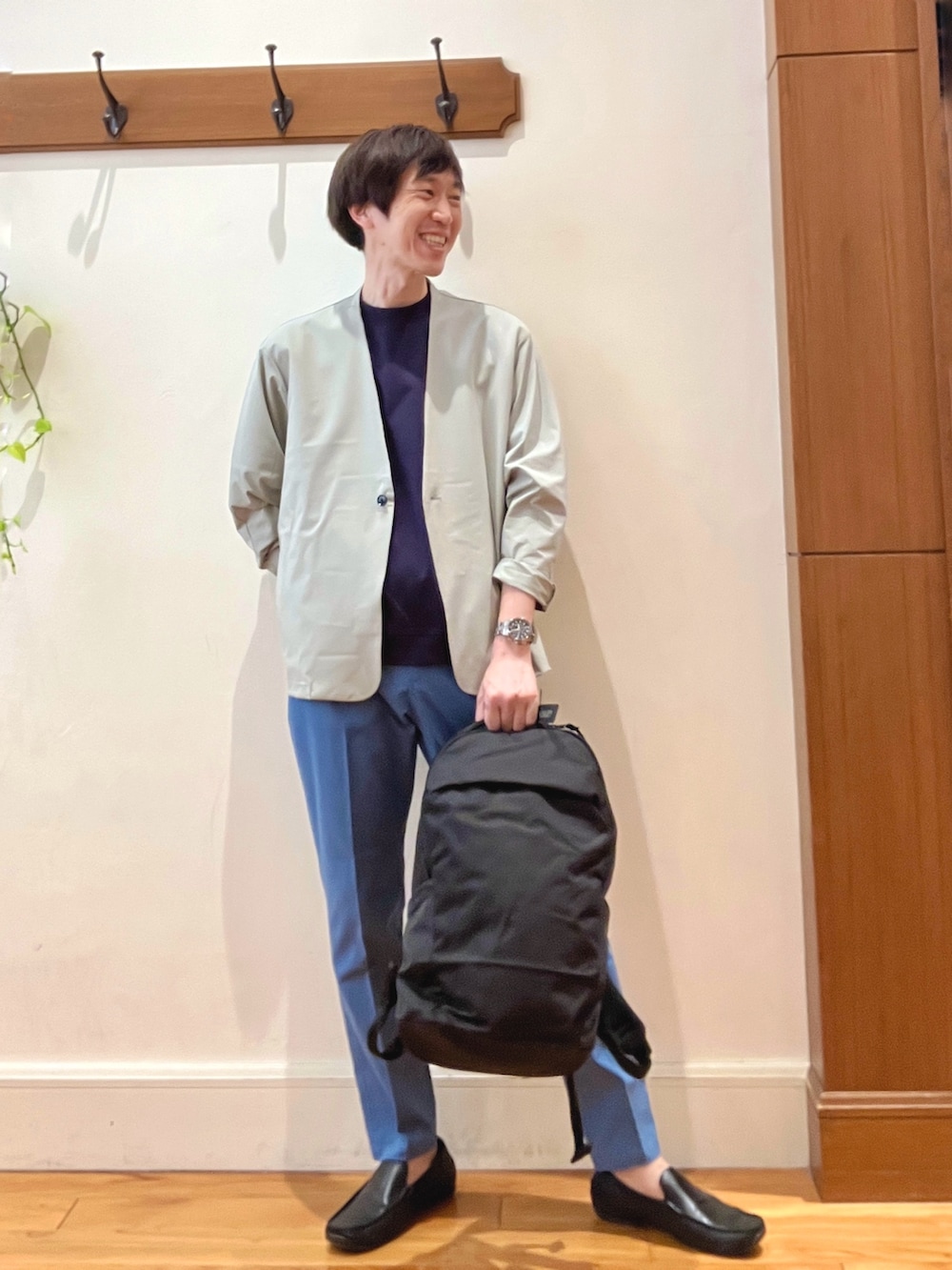 ブラック系のバックパック/リュック、ブルー系のチノパンツ、ブルー系のTシャツ/カットソーを着用したメンズの春コーディネートの9枚目の写真