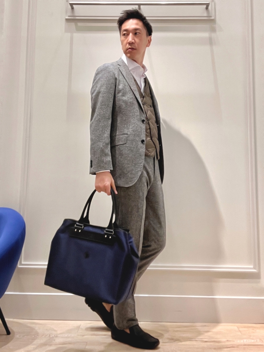 グレー系のテーラードジャケット、グレー系のスラックス、ブラック系のトートバッグを着用したメンズの秋コーディネートの5枚目の写真