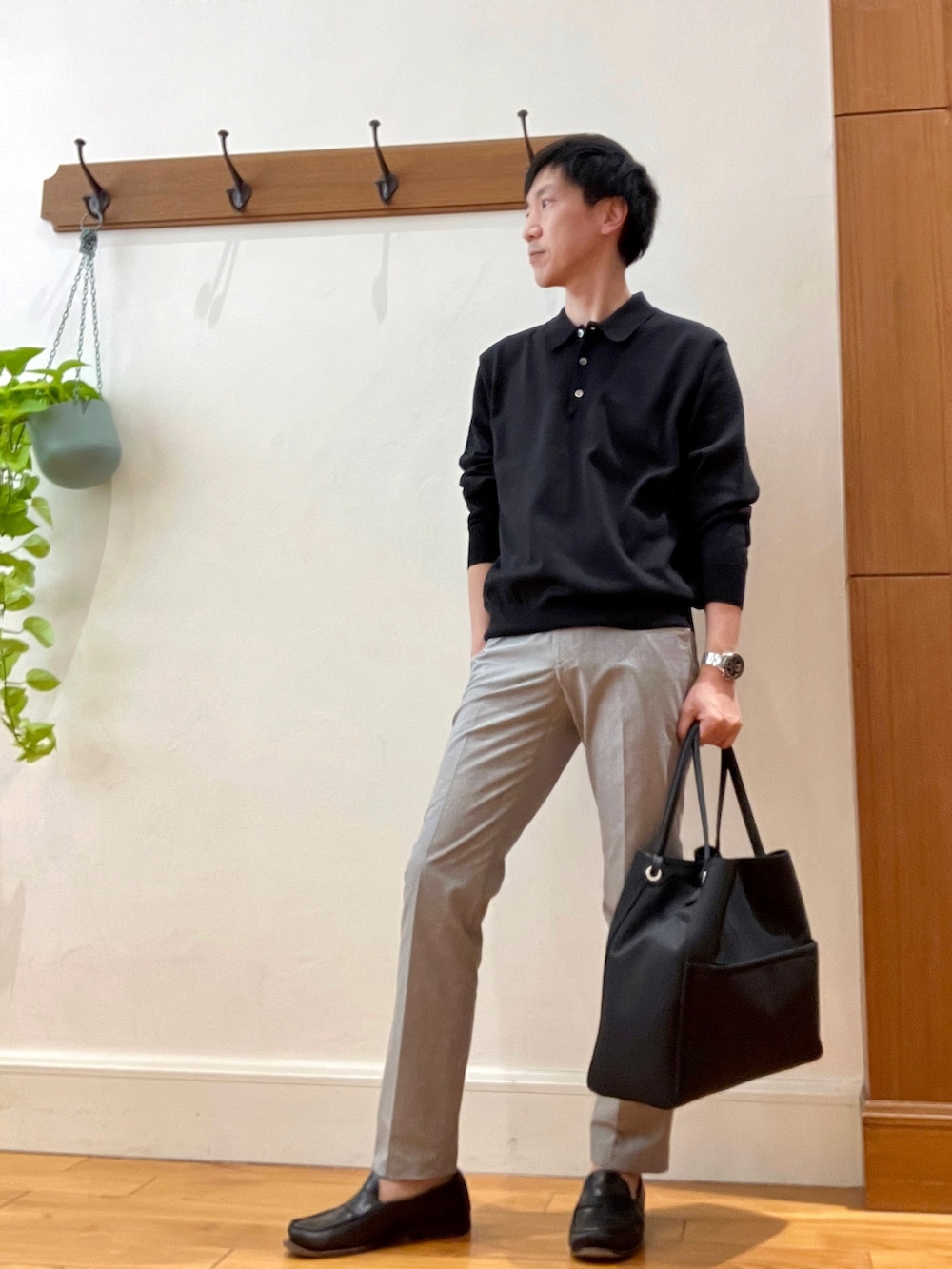 ブラック系のニット/セーター、ベージュ系のその他パンツ、ブラック系のトートバッグを着用したメンズの春コーディネートの2枚目の写真