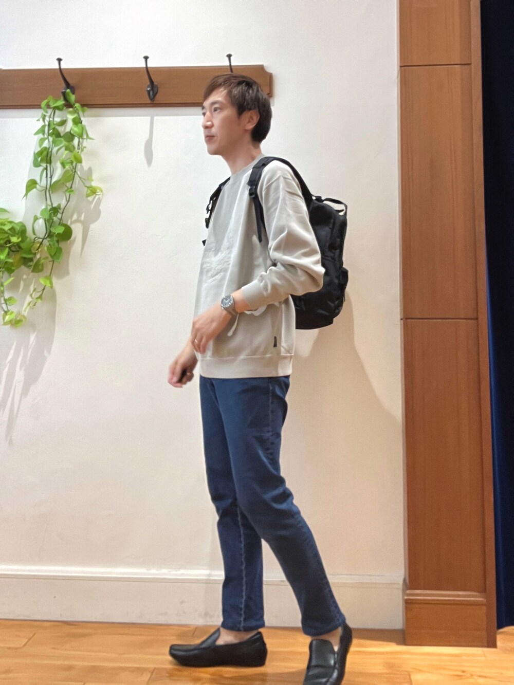 ベージュ系のスウェット、ブルー系のデニムパンツ、ブラック系のバックパック/リュックを着用したメンズの秋コーディネートの2枚目の写真