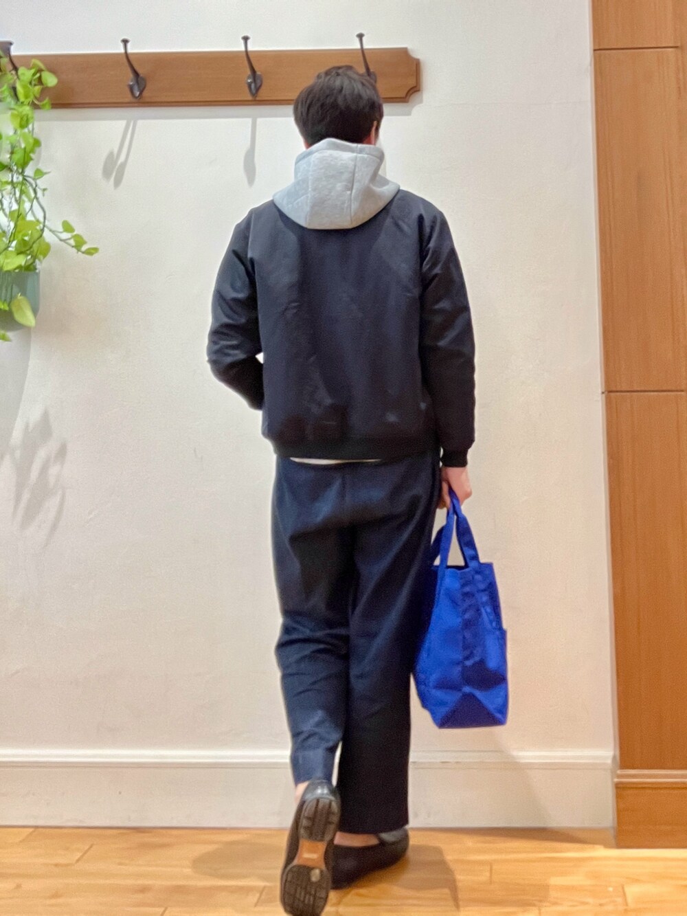 ブラック系のブルゾン、グレー系のパーカー、ブルー系のデニムパンツを着用したメンズの春コーディネートの4枚目の写真