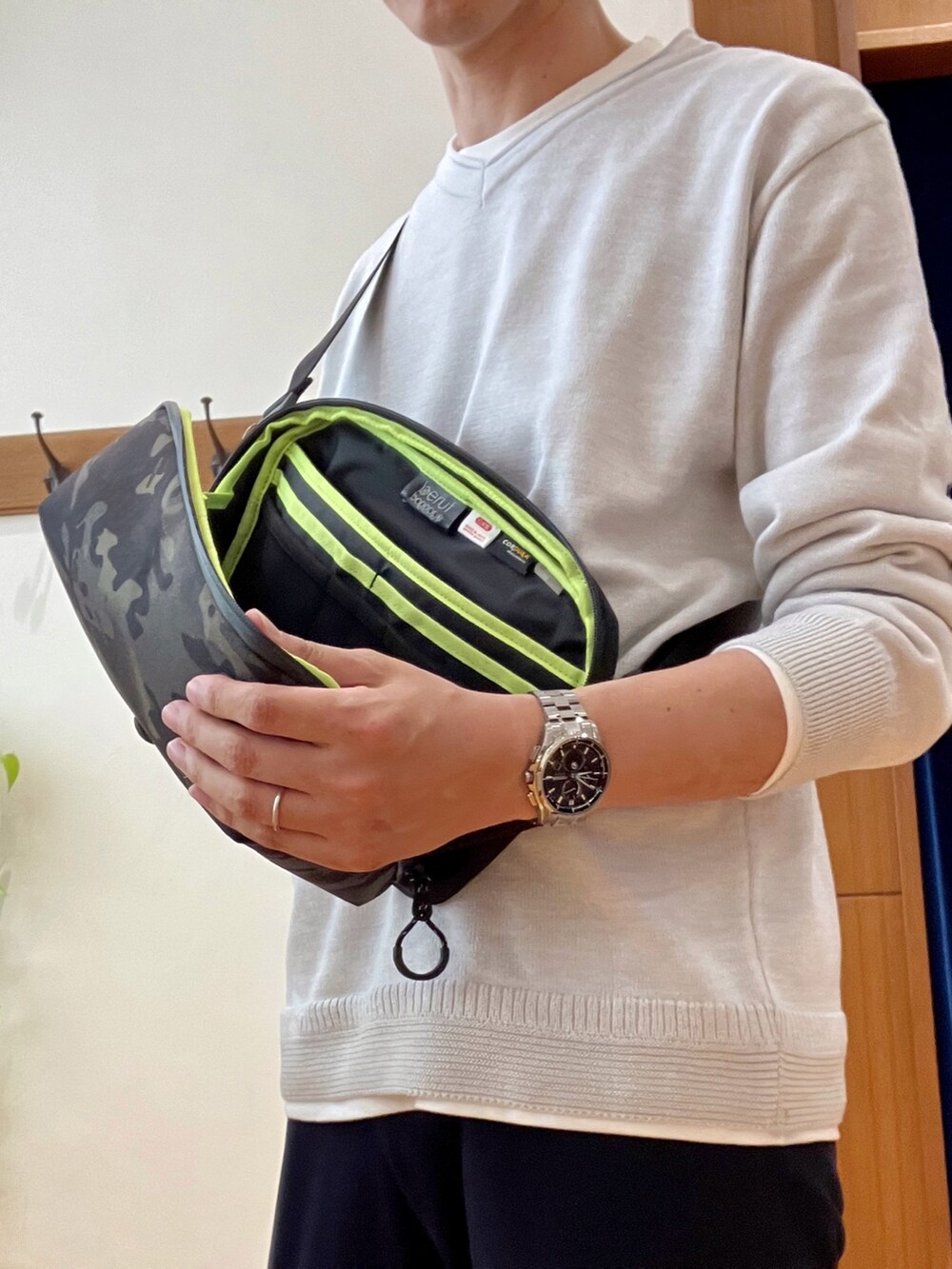 ブルー系のその他パンツ、ブラック系のショルダーバッグ、グレー系のニット/セーターを着用したメンズの秋コーディネートの6枚目の写真