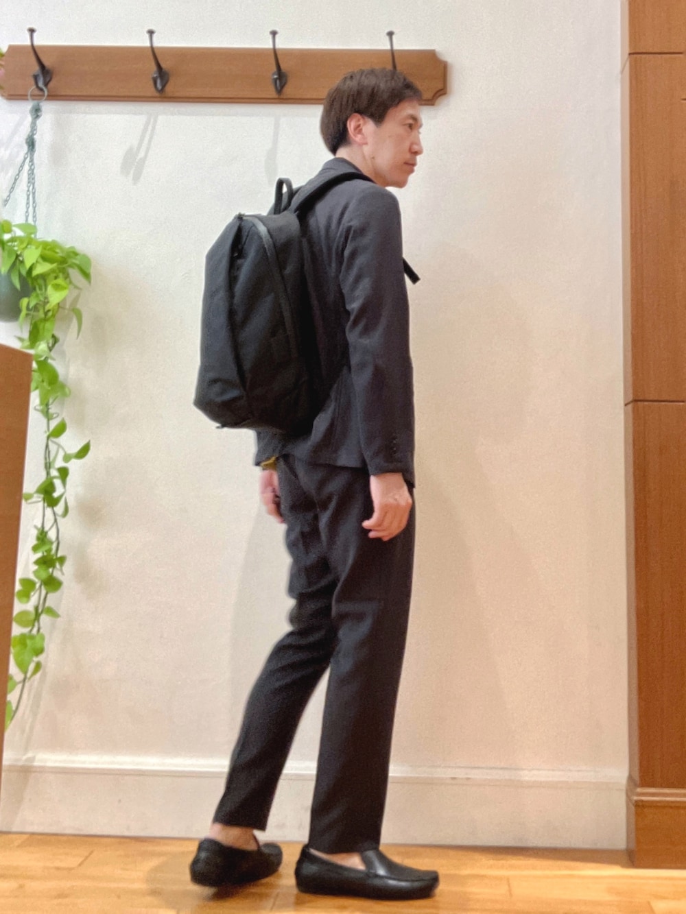 グレー系のテーラードジャケット、グレー系のその他パンツ、ブラック系のバックパック/リュックを着用したメンズの春コーディネートの6枚目の写真