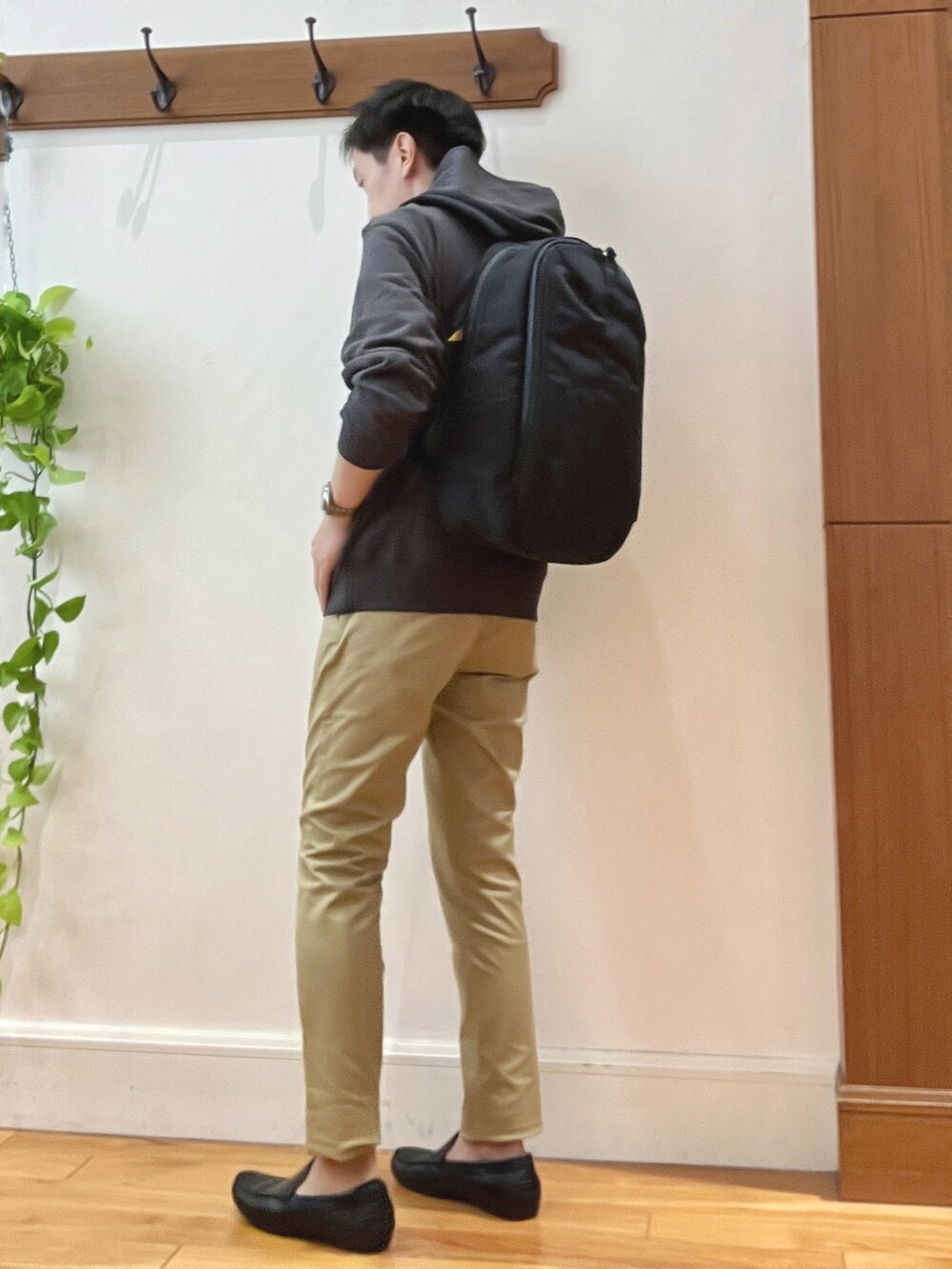 ベージュ系のその他パンツ、ブラック系のパーカー、ブラック系のバックパック/リュックを着用したメンズの秋コーディネートの4枚目の写真