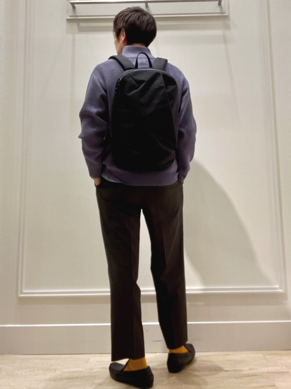 ブルー系のシャツ/ブラウス、ブルー系のニット/セーター、ブラック系のバックパック/リュックを着用したメンズの冬コーディネートの4枚目の写真