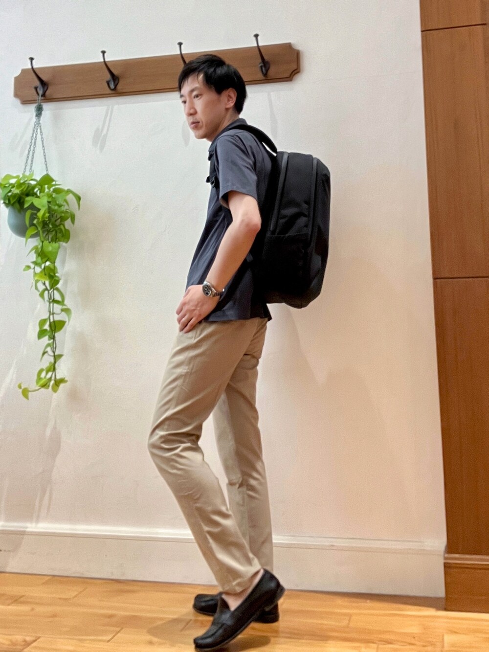 グレー系のポロシャツ、ブラック系のバックパック/リュック、ベージュ系のその他パンツを着用したメンズの春コーディネートの5枚目の写真
