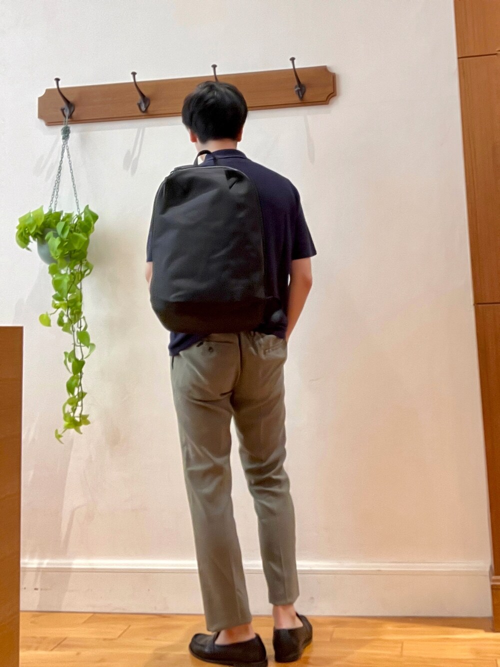 ブルー系のポロシャツ、ブラック系のバックパック/リュック、ブラック系のその他パンツを着用したメンズの春コーディネートの7枚目の写真