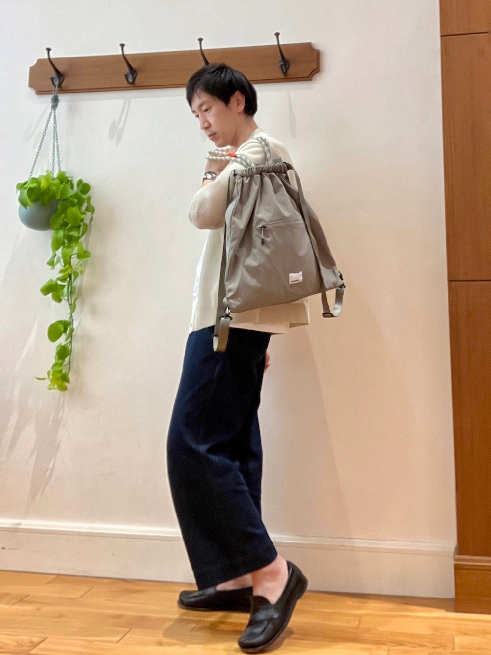 ベージュ系のカーディガン/ボレロ、グリーン系のトートバッグ、ホワイト系のTシャツ/カットソーを着用したメンズの春コーディネートの6枚目の写真