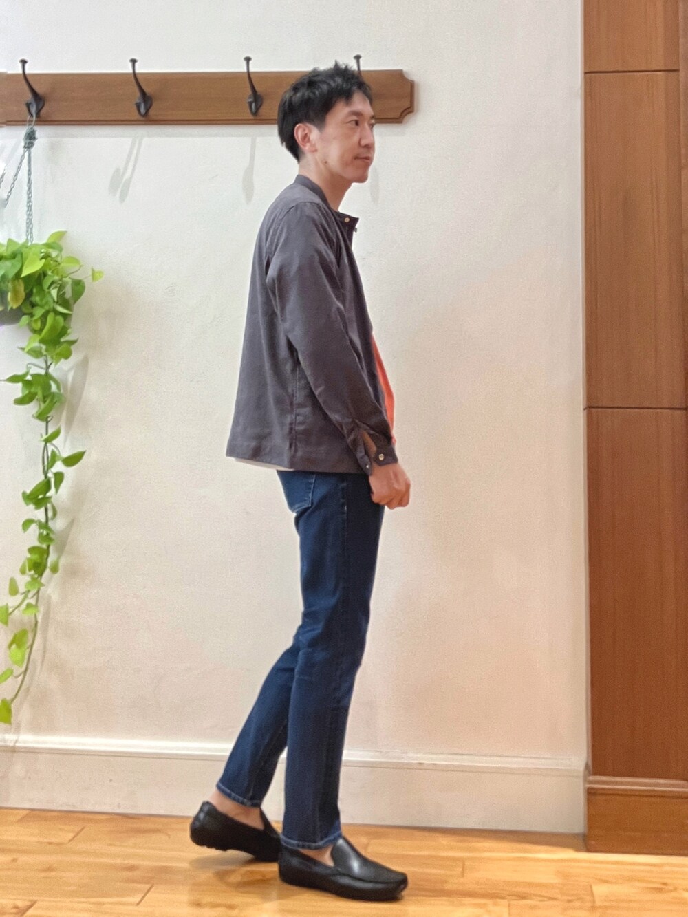 ブルー系のデニムパンツ、ブラック系のハンドバッグ、オレンジ系のTシャツ/カットソーを着用したメンズの秋コーディネートの6枚目の写真