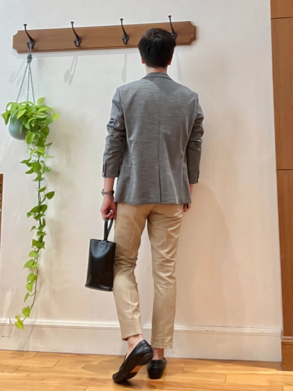 グレー系のテーラードジャケット、ブラック系のTシャツ/カットソー、ブラック系のハンドバッグを着用したメンズの秋コーディネートの5枚目の写真
