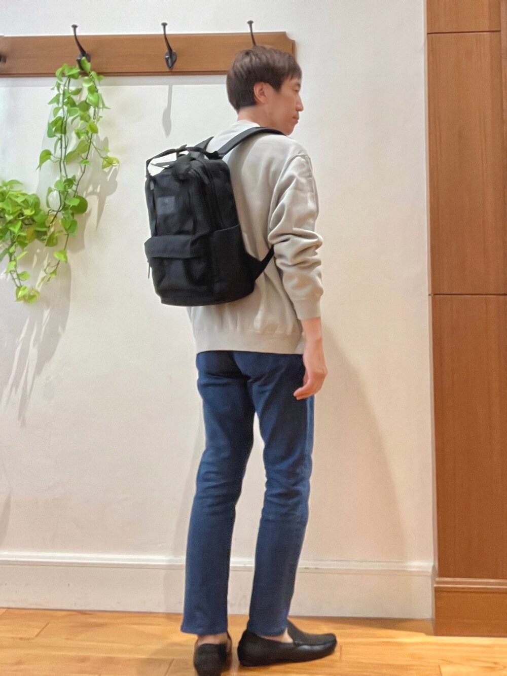 ベージュ系のスウェット、ブルー系のデニムパンツ、ブラック系のバックパック/リュックを着用したメンズの秋コーディネートの5枚目の写真