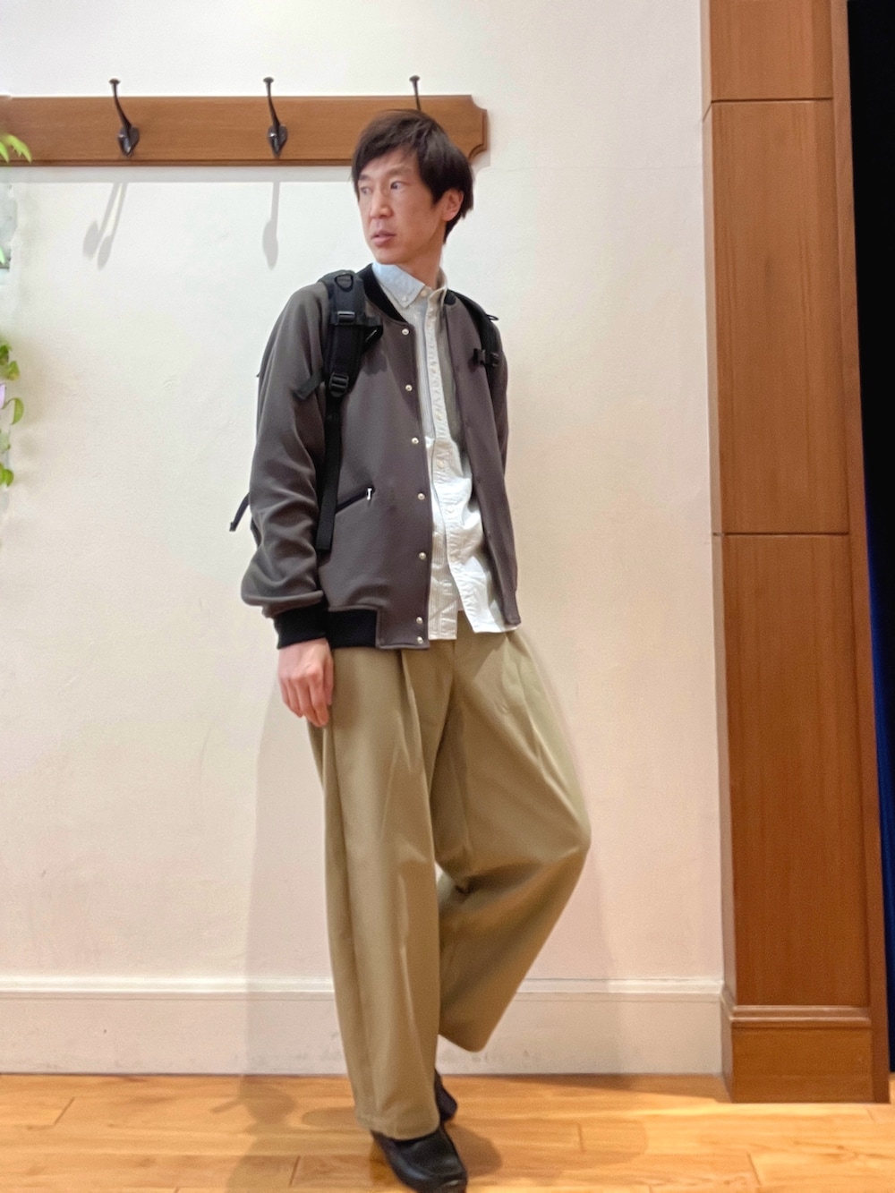 グレー系のブルゾン、グリーン系のシャツ/ブラウス、ブラック系のバックパック/リュックを着用したメンズの冬コーディネートの6枚目の写真